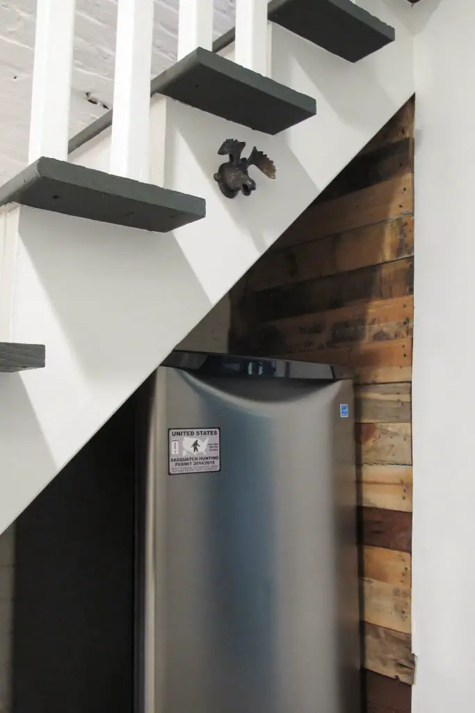 Basement mini fridge below painted and upgraded basement stairs.