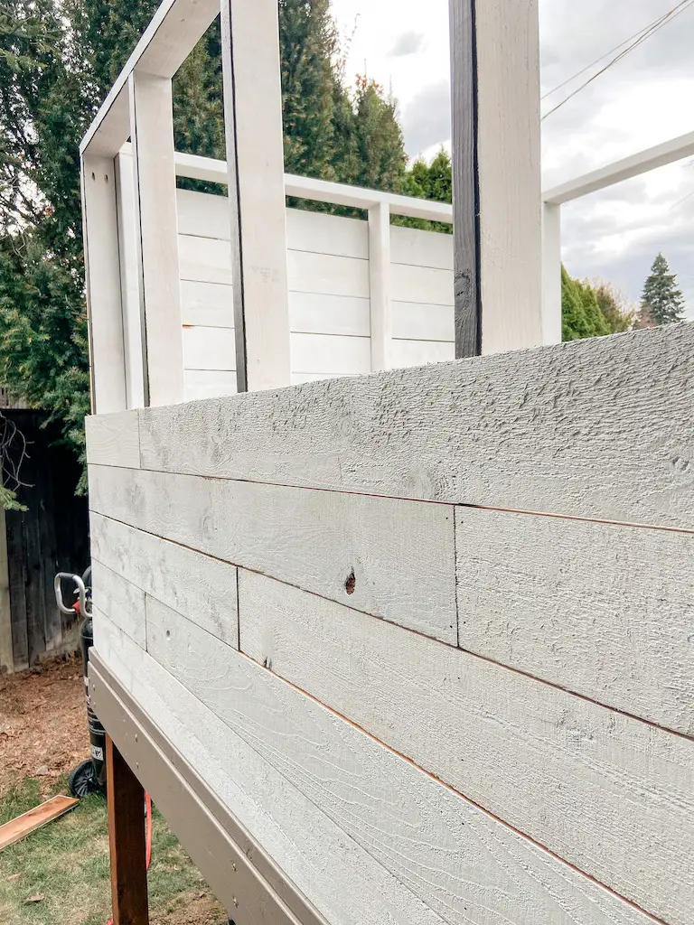DIY modern playhouse siding with cedar fence boards. Primer with oil-based paint. | EffieRow.com
#diyplayhouse #diycubbyhouse #cubbyhouse #playhouse #modernplayhouse #mcmplayhouse #playhousesiding #cubbyhousesiding #sherwinwilliamsblackfox