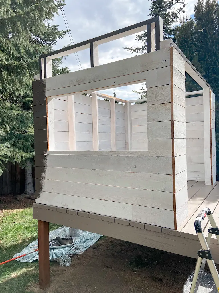 DIY modern playhouse siding with cedar fence boards. Primed with oil-based paint and painted Black Fox (SW) | EffieRow.com
#diyplayhouse #diycubbyhouse #cubbyhouse #playhouse #modernplayhouse #mcmplayhouse #playhousesiding #cubbyhousesiding #sherwinwilliamsblackfox
