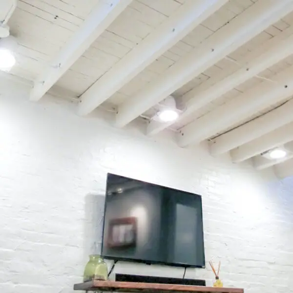 Exposed floor joists painted white in basement